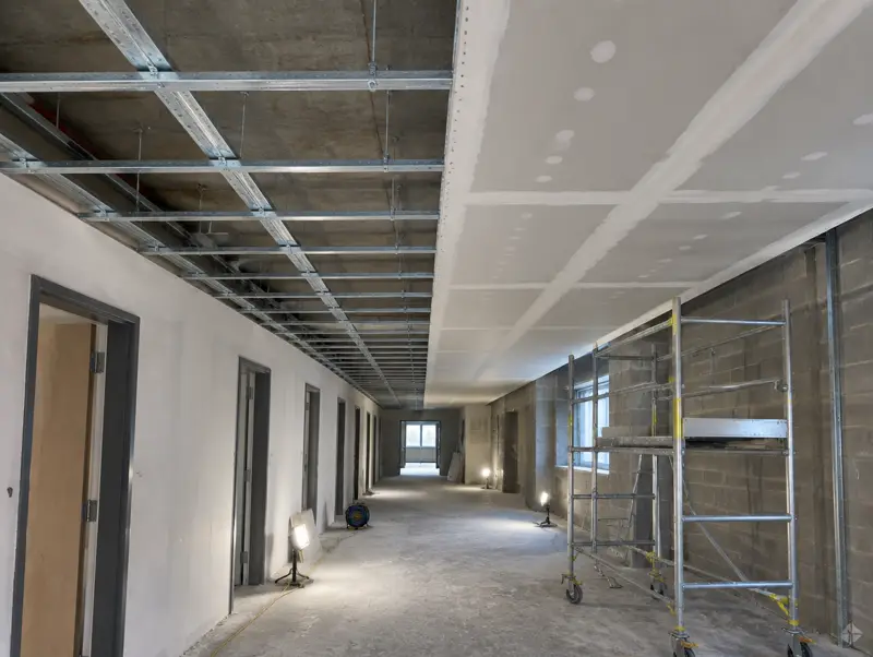 MF concealed ceiling framework half boarded with plasterboard in a commercial corridor