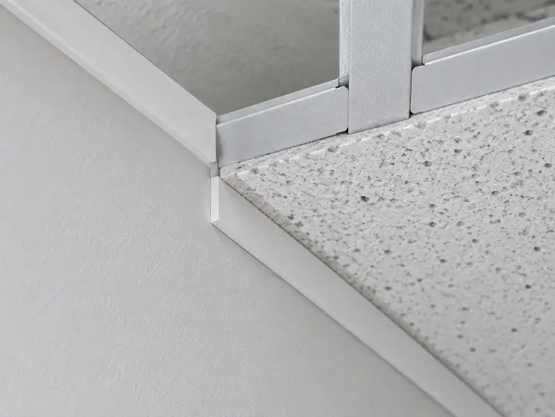Detail of a suspended ceiling corner with wall angle, tees and a cut tile